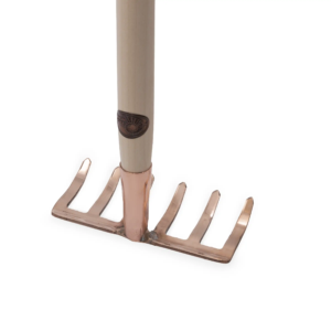 Kupferrechen mit fünf Zinken, kupferfarbener Kopf und hellem Holzstiel, mit einem logoembellierten Griff.