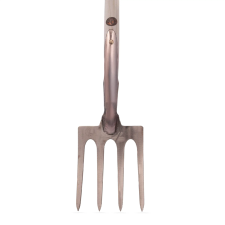 Kupferne Grabgabel mit vier spitzen Zinken, glattem Griff und einer markanten Verbindung am Ende des Griffs.