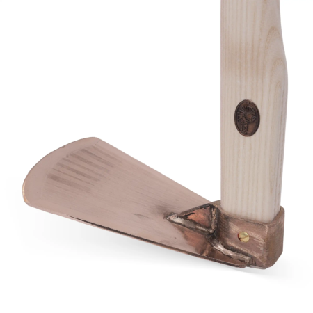 Kupferne Weinhaue mit einem hellen Holzgriff, der eine markante Verbindung zum kupferfarbenen Arbeitsblatt aufweist.
